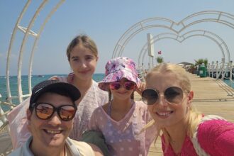 Die 2 Kinder und Christoph mit seiner Frau vor dem Meer.